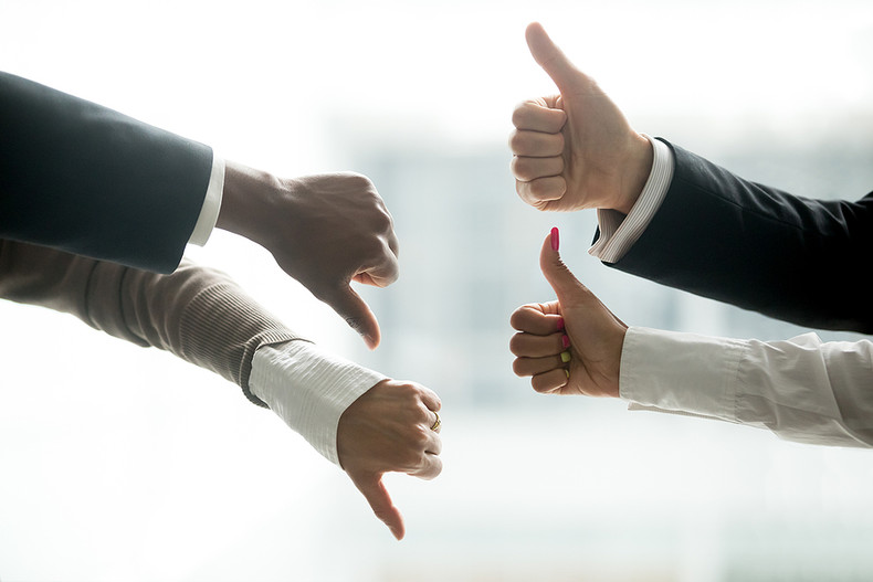 Business People Two Thumbs Up Two Thumbs Down Indicating a Difference of Opinion