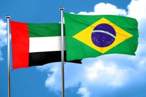 Flags of the UAE and Brazil Against Blue Cloudy Sky