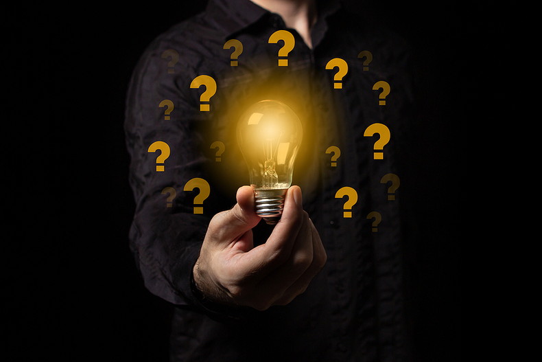 Man Holding Lightbulb with Question Marks