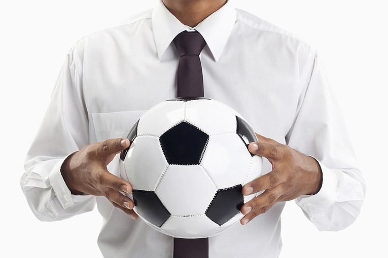 Man in Shirt and Tie Holding Football