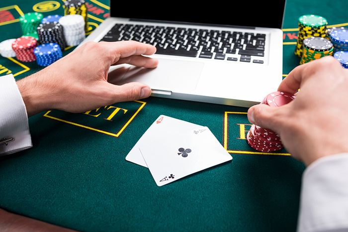 Man playing online poker on laptop